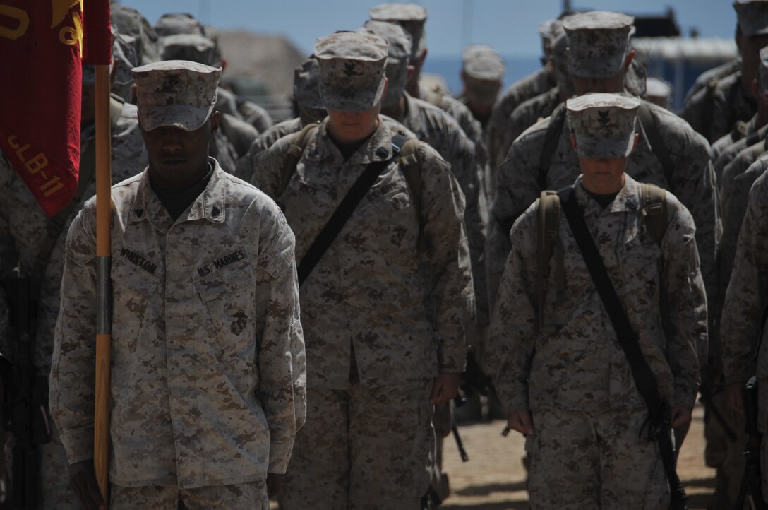 Marines and sailors with the 11th Marine Expeditionary Unit's logistics combat element bow their heads in prayer here June 19 during the 113th birthday of the Navy Hospital Corps, which was established on June 17 1898.
